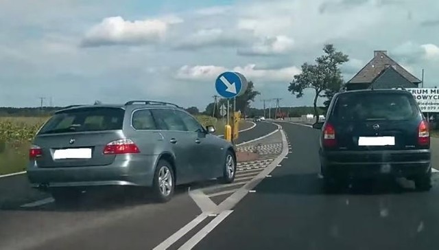 Kierowca BMW E61 wciska się między wysepkę a Opla Zafirę