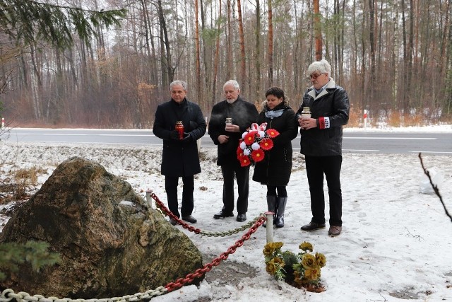 Delegacja składająca kwiaty i znicze przy pamiątkowym kamieniu przy lesie koło Piły