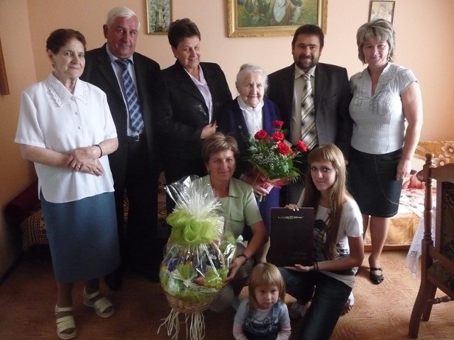 Stulatka Marianna Sideł wraz ze swoją rodziną oraz przewodniczącym Rady Gminy Piekoszów Jerzym Głuchem i wójtem gminy Piekoszów Tadeuszem Dąbrową, podczas przyjęcia urodzinowego.