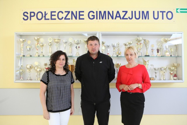 Klaudia Sołoduch (z prawej) z Martą Stetsko, dyrektor szkoły i Piotrem Piszko, trenerem piłki nożnej zapraszają do nowej szkoły.