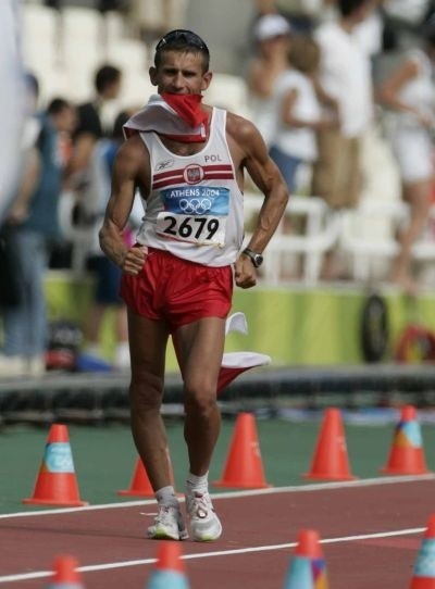 Z  flagą biało-czerwoną w zębach, rzuconą mu z trybun, kończył wczoraj Robert Korzeniowski chód na 50 kilometrów. Doszedł na metę pierwszy i zdobył swój czwarty złoty medal na trzeciej już olimpiadzie. To nasz najbardziej niezawodny olimpijczyk.