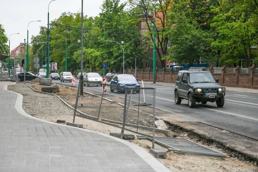 Kierowcy, piesi i pasażerowie tramwajów jadących ulicą...