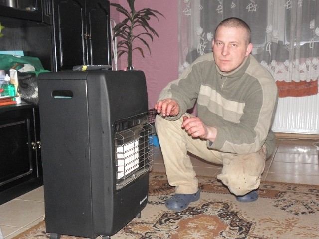 Krzysztof Najdowski grzeje się przy piecyku gazowym pożyczonym od znajomego