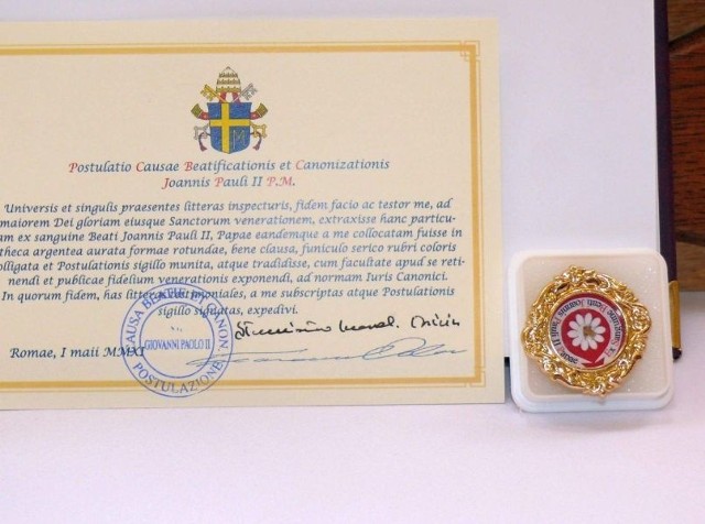 Tymczasowy relikwiarz z relikwiami Jana Pawła II i certyfikatem poświadczającym ich prawdziwość.