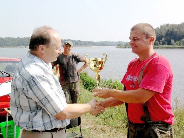 Paweł Kalista (z prawej), zwycięzca wśród seniorów, odbiera puchar z rąk wójta Andrzeja Przygody. Wszystkie złowione ryby wróciły do wody
