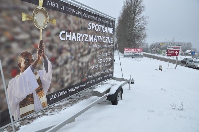 Spotkanie z księdzem Johnem Bashoborą reklamują tablice ustawione przy szczecineckiej obwodnicy.