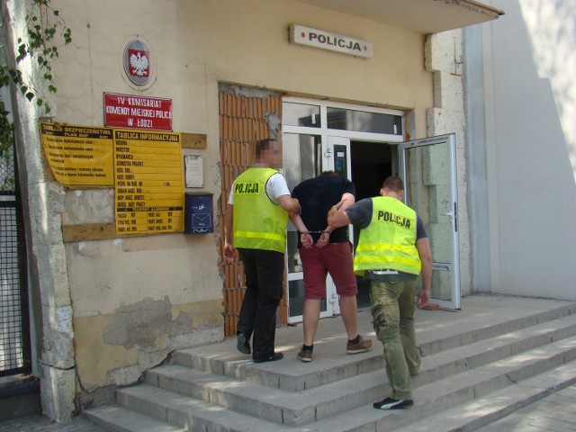 Policjanci prowadzą zatrzymanego zleceniodawcę rozboju - Dawida B.