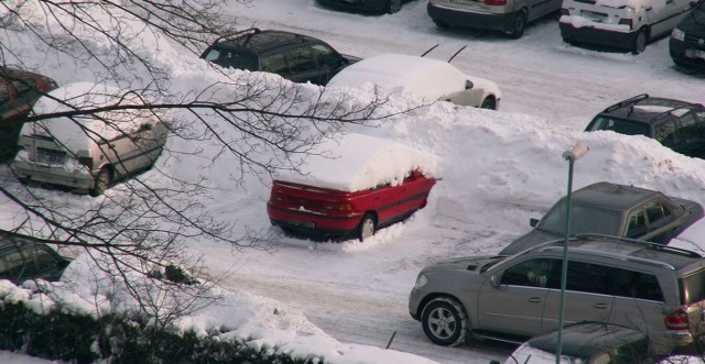 Zdjęcie parkingu strzeżonego przy ul. Waszyngtona w Białymstoku. Ciekawe jak te samochody wyjadą. I czy wcześniej śnieg nie zgniecie ich masek.