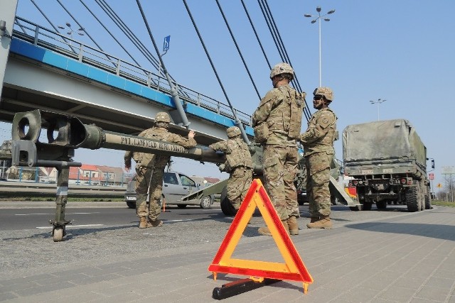 Awaria sprzętu wojskowego należącego do armii USA zablokowała ruch na Szosie Lubickiej w Toruniu. Niełatwo wydostać się z miasta w kierunku Warszawy i Olsztyna. Jeden z pasów Szosy Lubickiej – głównej prowadzącej na wschód arterii miasta – zablokowała kolumna wojskowych samochodów należących do armii USA.Na miejscu jest policja. Całkowicie zablokowany został prawy pas ruchu w kierunku Rubinkowa, co w godzinach szczytu mocno utrudnia komunikację. Jak udało się nam ustalić, awarii uległa platforma przewożąca ogromne działo. Chodzi konkretnie o jedno z kół, w którym pękł element konstrukcyjny.Kolumna amerykańskich samochodów wojskowych (ok. 15 aut) przejechała przez Wisłę mostem im. gen. Elżbiety Zawackiej i skręcała na wschód, w kierunku Rubinkowa. I właśnie tam doszło do awarii. Żołnierze przy pomocy policjantów i specjalistycznego sprzętu próbowali usunąć z drogi uszkodzoną platformę. Służby miejskie informują, że ruch w okolicach placu Daszyńskiego został przywrócony. Zobacz też: wypadek transportu sprzętu armii USA w Kowalewie PomorskimPolecamy:Gwara policyjna - tak nazywają marki autZarobki gwiazd disco-poloDługie weekendy 2018Skąd się wzięły nasze nazwiskaZobacz też desant amerykańskich wojsk na toruńskim poligonie:NowosciTorun