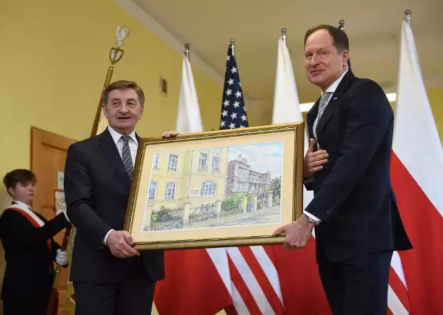 Pamiątkowy obraz autorstwa Marka Mikruta dla ambasadora Brzezińskiego. Widzimy na nim szkołę przy ul. Sienkiewicza, a tuż obok dom Brzezińskich.