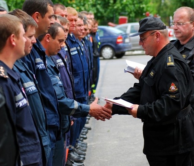 Starszy brygadier Zbigniew Muszczak, szef świętokrzyskich strażaków, wręcza strażakom z Ukrainy podziękowania na piśmie.