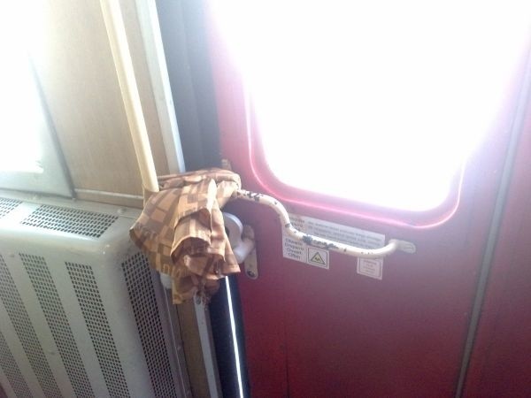 Drzwi w pociągu, które nie chciały się zamknąć, "naprawiono" firanką.