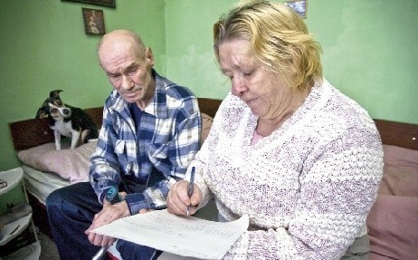 Pani Maria wraz z mężem Ryszardem piszą podanie z prośbą o przyspieszenie terminu badań. 
