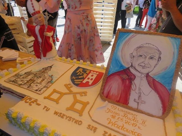 W Wadowicach mieszkańcy wspólne jedzą na rynku tort z podobizną papieża.