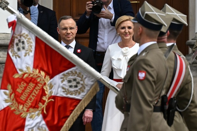 Prezydent Andrzej Duda i pierwsza dama Agata Kornhauser-Duda rozdali flagi państwowe. Uroczystości na Placu Zamkowym w Warszawie