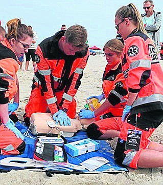 Na plaży w Darłówku Zachodnim przeprowadzono symulacje medyczne. Ćwiczenia zorganizowali studenci Ratownictwa Medycznego Akademii Pomorskiej w Słupsku.Topielec i pacjent w śpiączce - to tylko część z ćwiczeń, które wykonywali studenci Akademii Pomorskiej w Słupsku. Symulacje rozpoczęły się od pokazu głównego, którym była scenka przedstawiająca topiącego się człowieka. Wydarzenie przykuło uwagę turystów wypoczywających na plaży. - To są już nasze szóste manewry ratownictwa medycznego. Głównym celem jest przećwiczenie symulacji w warunkach rzeczywistych. Studenci kierunku Ratownictwo Medyczne słupskiej uczelni ćwiczą w salach przez trzy lata, a teraz mieli okazję wyjść na zewnątrz i sprawdzić swoje umiejętności - mówi nam Monika Rut, główna organizatorka akcji. W trakcie symulacji można było zobaczyć przypadek zatrzymania krążenia u pacjenta z bólem w klatce piersiowej. Ratownicy medyczni musieli wdrożyć wszystkie czynności ratunkowe. Była też sytuacja, w której poszkodowany został przejechany przez samochód, w wyniku czego konieczna była amputacja ręki. Kolejną symulacją był pacjent, który stracił przytomność na plaży. - Takie akcje jak ta jest potrzebna dla studentów, którzy nie są w stanie się nauczyć wszystkiego w pomieszczeniach zamkniętych. Dlatego ćwiczenia w warunkach rzeczywistych dają poczucie klimatu takich sytuacji. Im więcej ćwiczeń tym lepiej, będziemy bardziej pewni, że wszystko się uda - dodaje Monika Rut. W manewrach wzięło udział łącznie 90 osób. W akcję zaangażowany był także Zachodniopomorski WOPR oraz Uniwersytet Medyczny w Poznaniu.