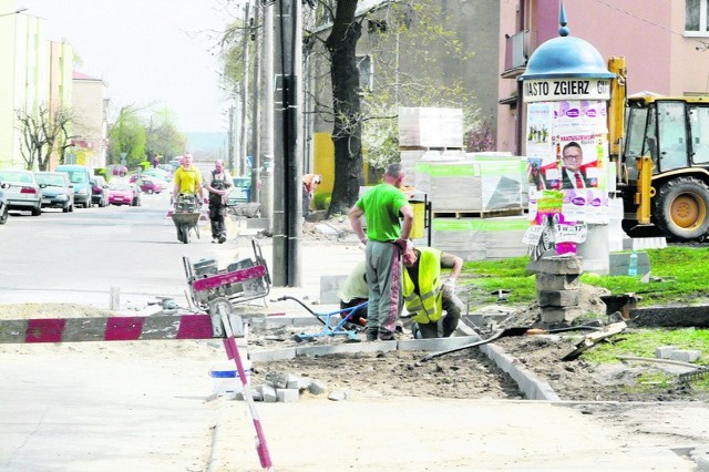 Ekipa brukarzy układa chodnik na ulicy Dubois.