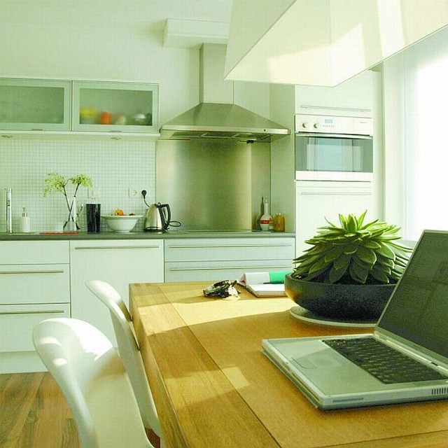 Prostota i oszczędna kolorystyka dominujące w kuchni i w pokoju sprawiają, że oba wnętrza tworzą jeden styl.