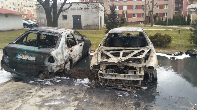 Spalone dwa auta, między nimi druty po podpalonych oponach