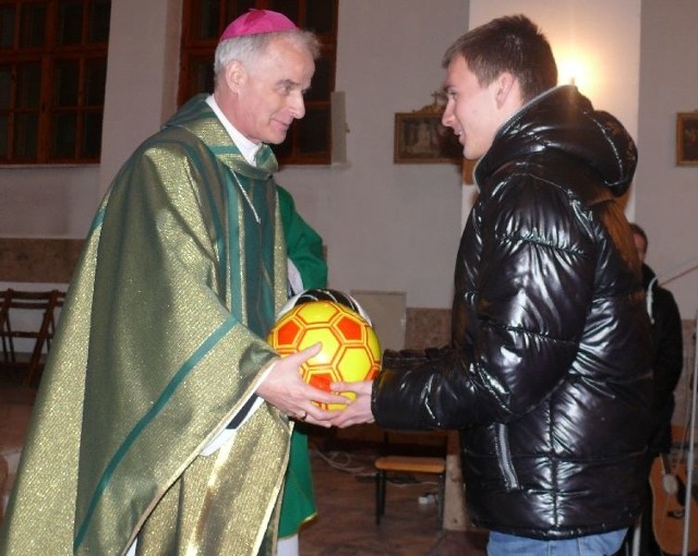 Bartosz Papka wręcza prezenty biskupowi Florczykowi