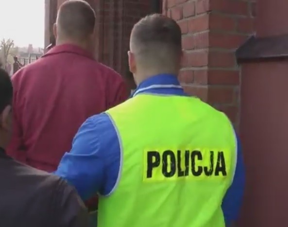 Zatrzymany mężczyzna eskortowany przez policjantów