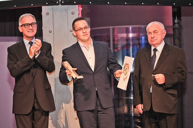 Maciej Mielewczyk (w środku) odbiera nagrodę za półbuty model 3153.