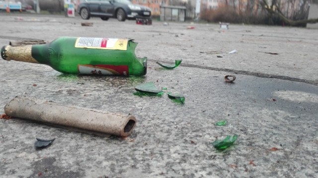 Kilka dni po sylwestrze na placu Zwycięstwa nadal leżą pozostałości po zabawie: potłuczone butelki po alkoholu oraz kartonowe opakowania po fajerwerkach. Problem w tym, że plac do czasu budowy nowej siedziby Sądu Rejonowego służy mieszkańcom jako parking. Codziennie stoi tam kilkadziesiąt samochodów. Zobacz także: Anna Kudenczuk. Oto pierwszy toruński noworodek w 2018 roku! [ZDJĘCIA]Wspomniany teren w 2015 roku przeszedł na własność Skarbu Państwa, a jest w administracji Sądu Rejonowego w Toruniu. Miasto przekazało nieruchomość z myślą o budowie nowej siedziby toruńskiej Temidy. Niestety, wczoraj mimo wielokrotnych prób nie udało się nam skontaktować z przedstawicielami sądu.Sprawę zaśmieconego placu przekazaliśmy również toruńskiej Straży Miejskiej.- Skierujemy na miejsce dzielnicowego i jeśli zgłoszenie się potwierdzi, zobowiążemy właściciela do uprzątnięcia terenu - zapowiada Jarosław Paralusz, zastępca komendanta Straży Miejskiej w Toruniu.Plac Zwycięstwa był usłany butelkami i pozostałościami po racachNowosciTorun