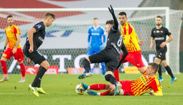 Korona Kielce - Cracovia 1:0 (1:0)Bramki: 1:0  Erik Pacinda 43. Korona:  Kozioł  - Spychała Ż,  Kovacević, Marquez Ż, Miletić Ż - Gnjatić, Żubrowski ŻŻCZ 75,  Pacinda Ż (90+3 Tzimopoulos), Zalazar CZ [41] Gardawski Ż (69. Djuranović) - Pućko (84. Jukić). Cracovia:  Pesković - Rapa, Helik, Jablonsky CZ 89, Pestka (67. Siplak) - Hanca, Lusiusz (46. Piszczek), Dimun Ż,  van Amersfoort Ż - Wdowiak (61.  Rakoczy Ż), Lopes. Sędziował:  Wojciech Myś z Lublina.Widzów:  4728.  Po niezwykle emocjonującym i dramatycznym meczu Korona Kielce pokonała na Suzuki Arenie Cracovię 1:0 w meczu 19. kolejce PKO Ekstraklasy. Był to ostatni w tym roku występ ekipy trenera Mirosława Smyły przed kielecką publicznością. Zwycięską bramkę zdobył Erik Pacinda.Udany debiut Mileticia, dobry mecz Pućko w atakuW ekipie Żółto-Czerwonych zadebiutował Nemanja Miletić. Wystąpił na lewej obronie i ten występ na pewno należy ocenić pozytywnie. Miletić przez trzy ostatnie sezony grał w Partizanie Belgrad. W barwach tego klubu wystąpił w Lidze Europy oraz kwalifikacjach do Ligi Mistrzów. Partizan zapłacił za niego w 2016 roku 260 tysięcy euro, wykupując go z drużyny Javor-Matis. Do Korony dołączył w trakcie rundy jesiennej, ale do tej pory grał tylko w rezerwach w trzeciej lidze. W Koronie było kilka zmian w składzie - w ataku zagrał Matej Pućko, na lewej pomocy Michał Gardawski, a w środku pomocy Rodrigo Zalazar. Trzeba przyznać, że Pućko pokazał się z dobrej strony - zaliczył asystę, mocno dawał się we znaki defensywie gości. Bardzo dobry występ zanotował Erik Pacinda - strzelił zwycięskiego gola, walczył i udowodnił, że warto na niego stawiać. Bezsensowny faul Zalazara i gol PacindyPierwsze dwa strzały oddała Cracovia - po rzutach rożnych główkował David Jablonsky, ale nie trafił w bramkę. W 29 minucie Miletić ładnie uderzył z ponad 20 metrów, ale Michal Pesković nie dał się zaskoczyć. Był to pierwszy celny strzał w tym meczu. Drugi w 31 minucie oddał Rodrigo Zalazar, ale i tym razem bramkarz Cracovii był na posterunku.  W 40 minucie bezsensowny faul Rodrigo Zalazara w środku boiska - wyprostowaną nogą wszedł w Michała Helika. Najpierw sędzia pokazał mu żółtą kartkę, ale po chwili podjął decyzję, że skorzysta z VAR-u. Po obejrzeniu wideoweryfikacji zmienił zdanie, anulował żółtą kartkę i pokazał czerwoną. Urugwajczyk musiał opuścić boisko. W tym sezonie już nie zagra.  Po meczu bronił go jednak trener Mirosław Smyła. - Jest młody, bardzo chciał, ale zostawił serce i najważniejsze, że zespół wygrał. My potrzebujemy piłkarzy, a Rodrigo do takich należy. Mam nadzieję, że nie mówię na wyrost i odda to w kolejnych tygodniach - zaznaczył szkoleniowiec.W 43 minucie błąd popełnił Sylwester Lusiusz, piłkę przejął Matej Pućko, podał w tempo do Erika Pacindy. Ten uderzył z pierwszej piłki w długi róg i zdobył bramkę. Ogromna radość zapanowała na Suzuki Arenie.Dwie „czerwienie”  i żółte kartki dla trenerówKorona, mimo że grała w osłabieniu, to odważnie zaczęła drugą połowę. W 49 minucie po składnej akcji ładnie uderzył Michał Gardawski, ale Peskovć nie bez problemu obronił ten strzał w krótki róg. W odpowiedzi bramce Korony zagroził Filip Piszczek, ale Marek Kozioł nie dał się zaskoczyć. W 65 minucie ponownie strzelał Piszczek, ale Kozioł znowu udanie interweniował.W 75 minucie drugą żółtą a w konsekwencji czerwoną kartkę za faul taktyczny otrzymał Jakub Żubrowski. Na nic zdały się protesty jego i kolegów z drużyny. Korona musiała grać w dziewiątkę. Po chwili nie panujący nad tym, co działo się na boisku sędzia żółtą kartkę pokazał trenerowi Korony Mirosławowi Smyle. W 81 minucie za niesportowe zachowanie żółta kartkę ujrzał trener Cracovii Michał Probierz.W 89 minucie za niesportowe zachowanie - faul bez piłki na Urosie Djuranoviciu - czerwień otrzymał David Jablonsky.Ale emocje w końcówce! Kozioł  bohateremW końcówce były ogromne emocje. Sędzia doliczył 6 minut, a mecz trwał prawie 10 minut więcej. Kibice oglądali go już na stojąco. W 91 minucie Rafael Lopes był sam na sam i uderzył obok bramki. W 95 minucie Mateusz Spychała wybił piłkę z linii bramkowej. W 96 minucie przy rzucie rożnym na pole karnym pobiegł nawet bramkarz Cracovii, ale znakomite interwencje Marka Kozioła sprawiły, że Korona wygrała 1:0!Po meczu była wielka radość. Korona pokazała charakter. Grając w dziewiątkę ograła trzeci do tej kolejki zespół ekstraklasy.  - Buduje nas to, że przez ponad 50 minut graliśmy w osłabieniu, a przez ostatnie 20 minut w „9” i daliśmy radę, bo każdy walczył za każdego, oddawał serducho i to jest chyba meritum tego, że dzisiaj jesteśmy zwycięzcami.  Co prawda to jedno spotkanie nie zamyka walki, ale otwiera drzwi do dalszych bojów - powiedział po dramatycznym spotkaniu Mirosław Smyła. Dorota Kułaga