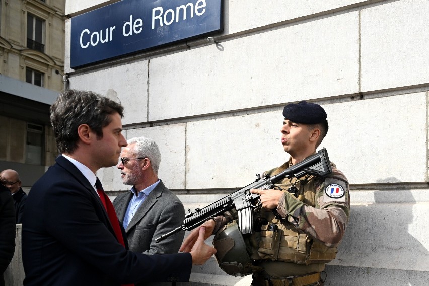 Premier Francji Gabriel Attal (po lewej) wita francuskiego...