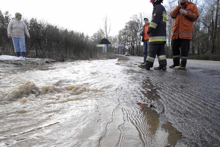 Woda splywająca z pól zalala droge w Lubuczewie.