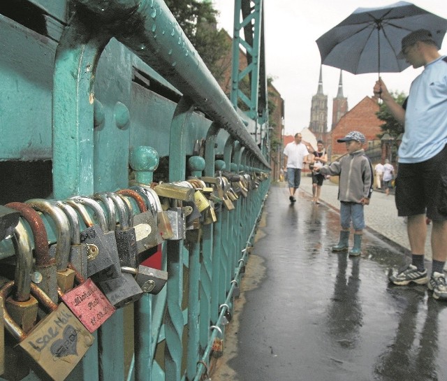 Zakochani wieszają kłódki na moście Tumskim we Wrocławiu
