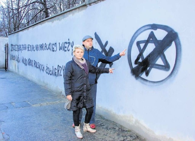 Małgorzata Mariowska i Tomasz Malec pokazują antysemickie bazgroły na murze kirkutu