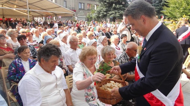 Gospodarze dożynek - na pierwszym planie burmistrz Wacław Gregorczyk - częstują gości chlebem