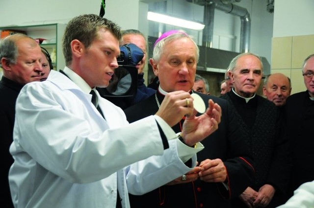 Karol Wierzbicki, właściciel piekarni, prezentuje hostię abp. Edwardowi Ozorowskiemu