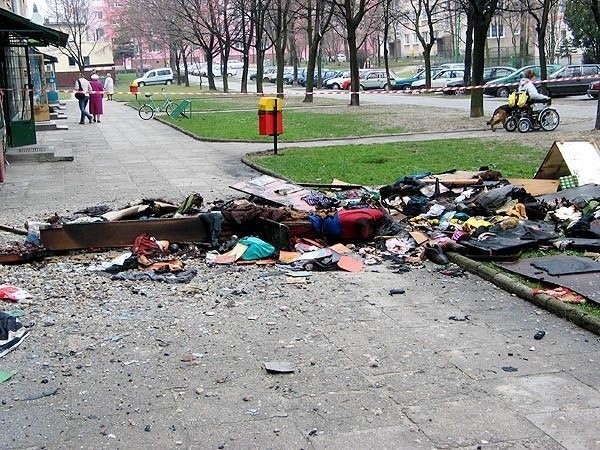 Resztki spalonych mebli i ubrań rozrzucone przed blokiem przy ulicy Solskiego