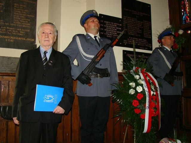 Karol Ptaszkowski, przed tablicą pamiątkową poświęconą ofiarom zbrodni katyńskiej w kościele WNMP w Oświęcimiu