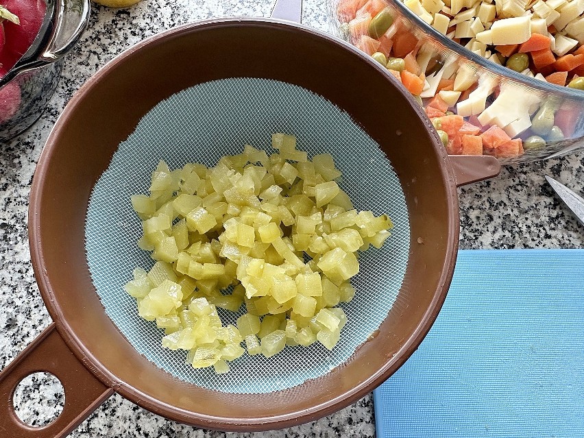 Dodaj odsączone ogórki do sałatki. Posiekaj cebulę i...