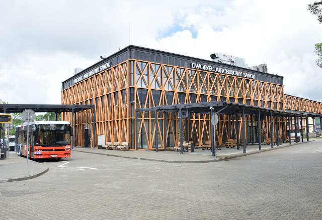 Dworzec przy ul. Lipińskiego ma być punktem skupiającym cały transport autobusowy i ruch pasażerski. Budowa nowoczesnego obiektu dobiegła końca. W czwartek (23 maja) został oficjalnie otwarty.- Do tej pory przewoźnicy korzystali z różnych miejsc i przystanków w mieście - mówi Jakub Radożycki z biura burmistrza Sanoka. Teraz do dyspozycji mają nowoczesny dworzec multimodalny. Obiekt ma dwie kondygnacje i blisko 1300 metrów kwadratowych powierzchni użytkowej. - Są w nim poczekalnie, przechowalnia bagażu, kasy, restaurację z zapleczem socjalnym, boksy sklepowe, punkt informacji turystycznej, pomieszczenia techniczne dla ochrony i kierowców oraz toalety - wylicza Tomasz Matuszewski, burmistrz Sanoka. - Działają ruchome schody oraz cztery windy, z czego trzy przy kładce łączącej dworzec multimodalny z dworcem kolejowym. Obok powstał parking i miejsce postoju dla taksówek.Miasto jest teraz na etapie wyłaniania administratora dworca. - Będzie znany na początku czerwca - mówi Tomasz Matuszewski. I dodaje, że do tego czasu obsługą przewoźników zajmie się urząd miasta i podległe spółki, tak by dworzec mógł działać.Zdaniem burmistrza obiekt będzie dworcem centralnym jeśli chodzi o trasy autobusowe w Bieszczady. - Linii przewozowych jest bardzo dużo, prawie 40 przewoźników przejeżdża przez Sanok i większość z nich wyraża chęć korzystania z tego dworca - mówi.Inwestycja za 16 mln zł powstała w ramach projektu "Wdrożenie zintegrowanego systemu ograniczenia niskiej emisji w ramach systemu transportu w Miejskim Obszarze Funkcjonalnym Sanok – Lesko". Całość projektu opiewa na kwotę 32 mln zł. Mieści się w tym także zakup 11 ekologicznych autobusów - 8 zasilanych CNG, 3 z silnikiem Diesla. Te dostarczył sanocki Autosan.ZOBACZ TEŻ: Nowe autobusy MPK w Rzeszowie będą jeździć na ekologiczny gaz ziemny