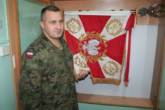 Pełniący obowiązki dowódcy major Sylwester Wlaszczyk prezentuje sztandar 16 Batalionu Saperów.