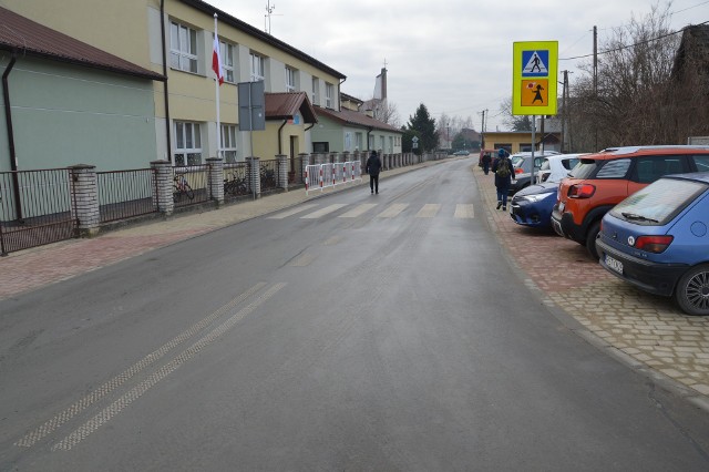 Centrum Pilchowa ze zmodernizowaną drogą, z lewej szkoła podstawowa, w tle wieża kościoła