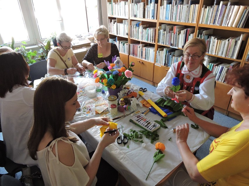 Marianna Pokora uczy robić kwiaty z bibułki.
