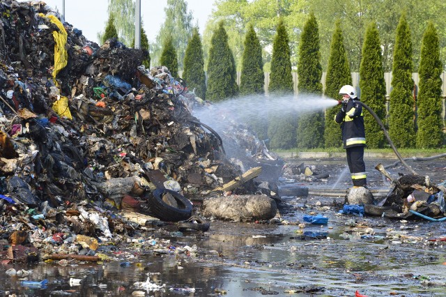 Na placu manewrowym Empolu strażacy przelewali wodą śmieci wywożone  ciężarówkami z hali