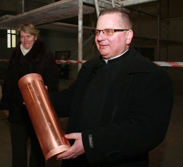 Tubę wmurował w kopułę kościoła proboszcz ks. Marek Rogeński SAC. Na drugim planie Arleta Jeziorska.