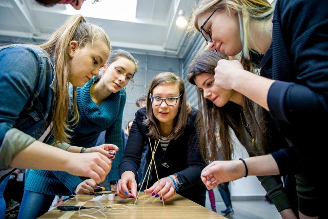 W hali Wydziału Architektury zgromadzili się studenci pierwszego roku architektury oraz obcokrajowcy przebywający na Politechnice Białostockiej w ramach programu Erasmus. W sumie aż 26 pięcioosobowych zespołów budowało na czas najwyższą wieżę. Każda ekipa miała do dyspozycji 20 makaronów spaghetti, metr nitki, metr taśmy klejącej oraz jedną piankę Marshmallow, która miała znaleźć się na szczycie konstrukcji.