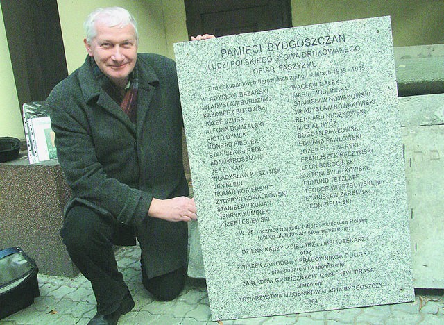 Wojciech Sobolewski pokazuje pamiątkową tablicę poświęconą...