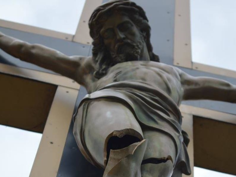 Zdjęcia uszkodzonego krzyża i figury Jezusa przed kościołem...