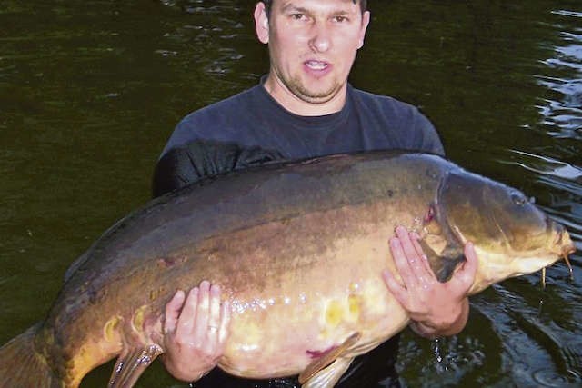 Marek Wiśniewski z karpiem, ważącym 30,5 kilograma. Ten okaz został złowiony w 2011 roku i do dziś jest oficjalnym rekordzistą połowu na dzikich wodach