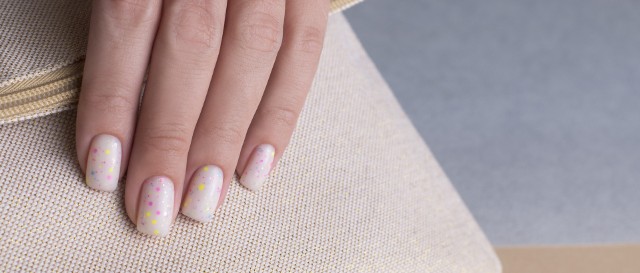 Confetti nails jest modne od kilku sezonów. Kolorystykę i intensywność wzorków można dopasować do swoich potrzeb. Zobacz, jak można wykonać manicure hybrydowy z tym motywem.