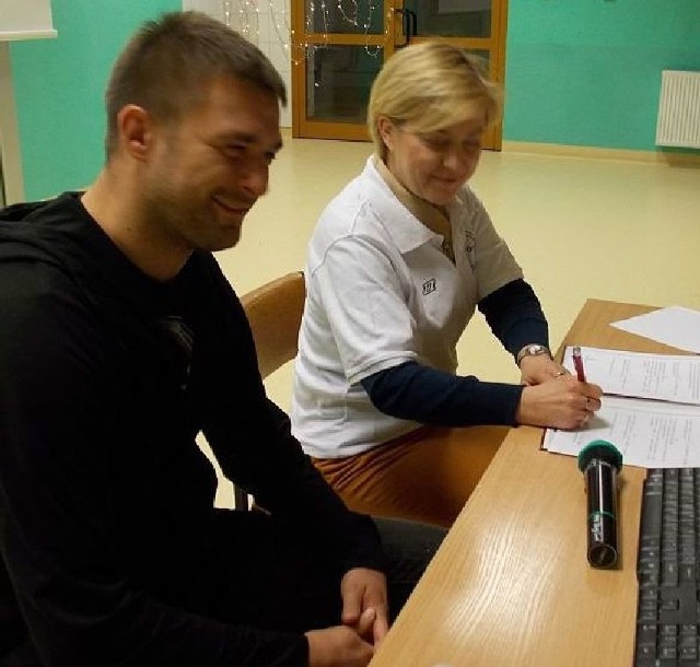 Piłkarz Dariusz Pietrasik oraz Barbara Kasińska, dyrektor Liceum Ogólnokształcącego w Zespole Szkół numer 2 podpisują dokumenty, które pozwolą piłkarzowi na formalne objęcie klasy 1 E patronatem.
