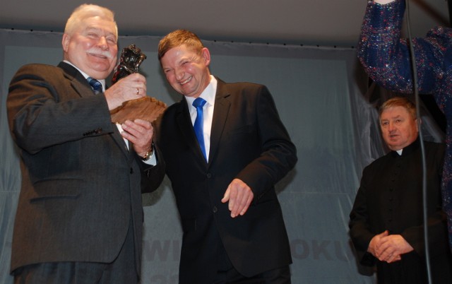 Statuetkę "Tłuchwianin Roku 2012" wręcza Lechowi Wałęsie wójt Krzysztof Dąbkowski. W głębi ks. Andrzej Zakrzewski, pomysłodawca plebiscytu.